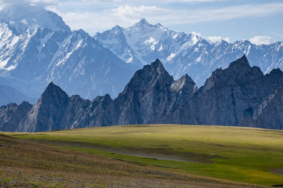 Patundas Trek Hunza Pakistan with panoramic views of alpine meadows and the Karakoram Mountains between Passu and Batura glaciers.